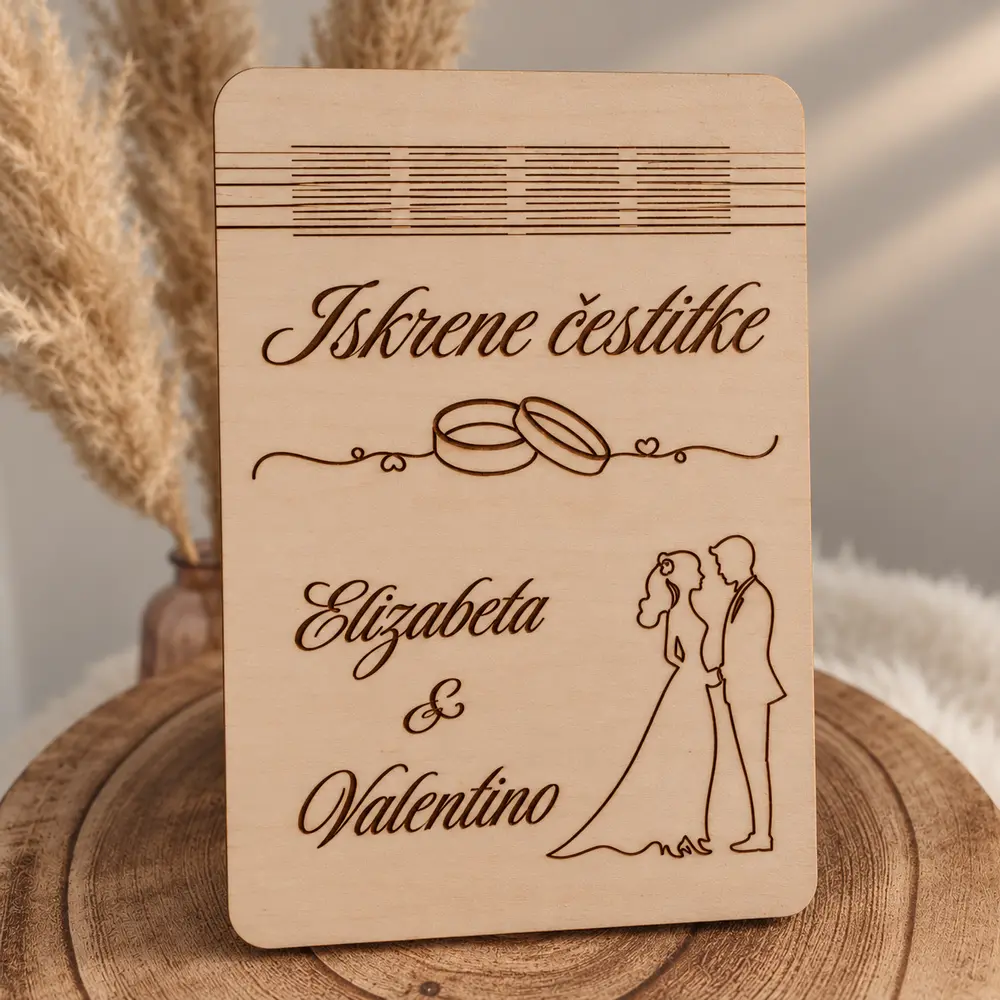 Zatvorena drvena čestitka za vjenčanje s gravurom mladenaca, prstenja i natpisom.
